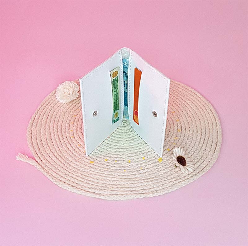 uma carteira branca aberta sobre um barbante em espiral