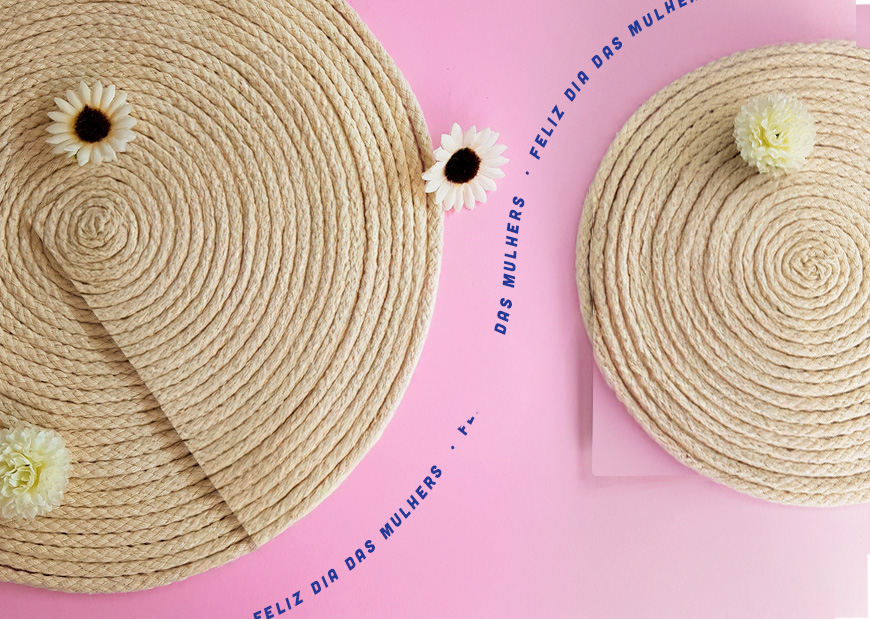 um fundo rosa com dois circulos de feito de barbante e uma frase escrita feliz dia das mulheres